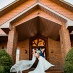 Bride and Groom in front of Sunset Valley Wedding Lodge